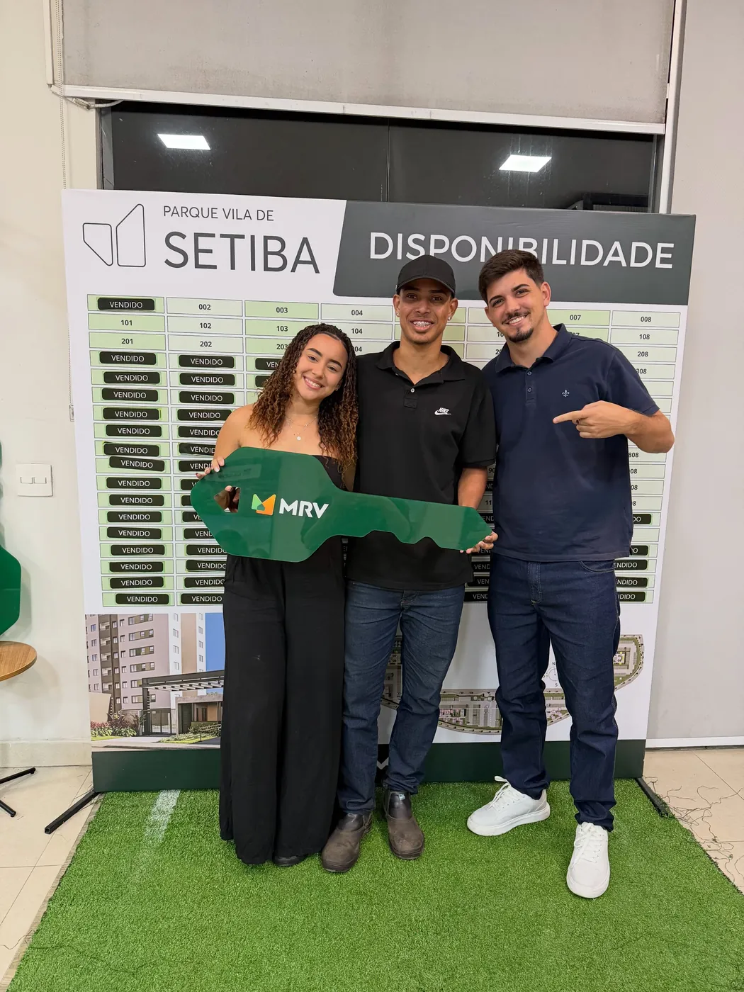 Gabriel Ferreira entregando a chave do apartamento novo a um casal de clientes